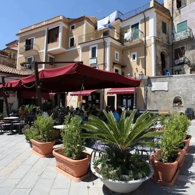 Dehors con ombrelloni rossi in piazza a Castellabate