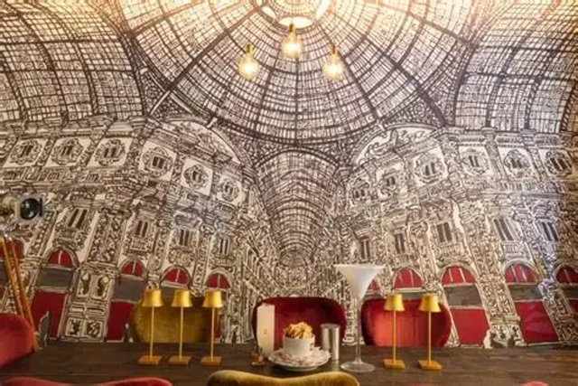 Sala di un ristorante a tema cinema con manifesti e luci calde